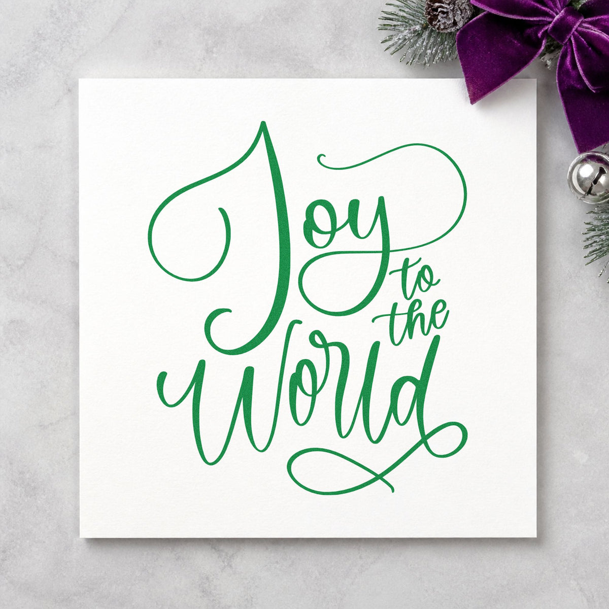 Joy To The World Thin Script craft stamp imprint in green ink on a handmade project, one idea being bridal shower menus.