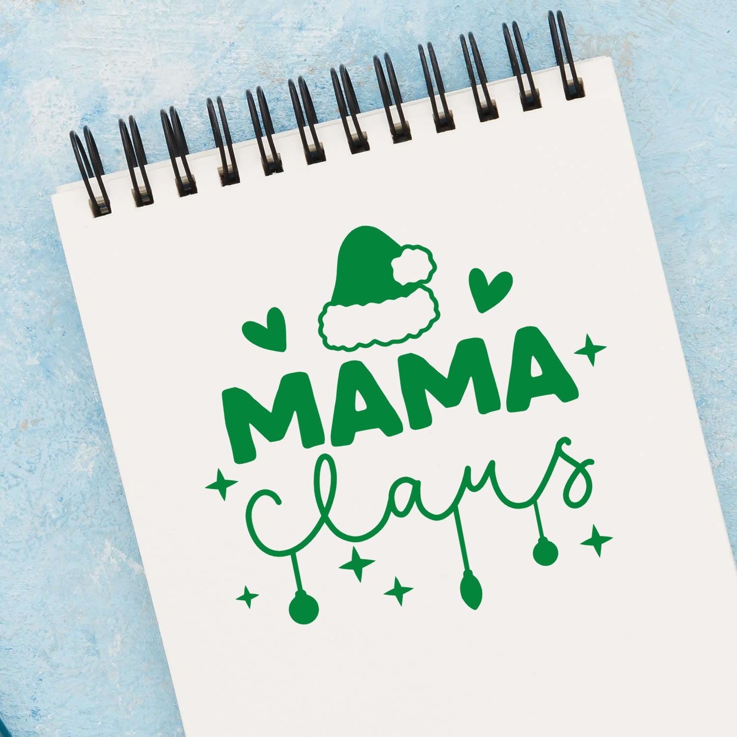 Mama Claus Christmas rubber stamp design with Santa hat, hearts and stars on a notebook page