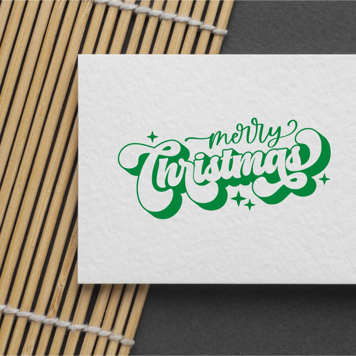 Green Merry Christmas rubber stamp design on white paper, perfect for holiday card making, scrapbooking, and festive crafts.