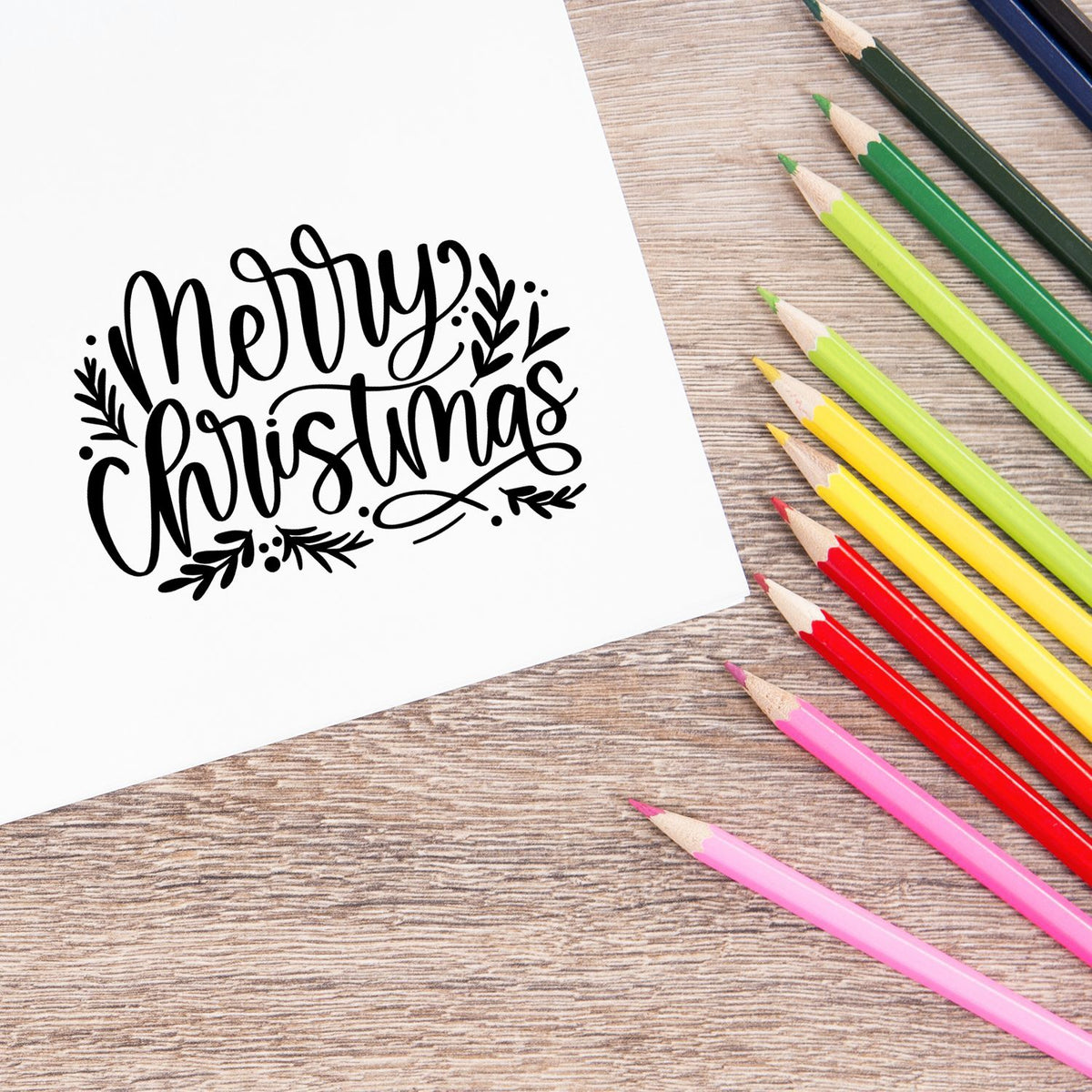 Merry Christmas rubber stamp design on paper with colored pencils, perfect for holiday card making and craft projects.
