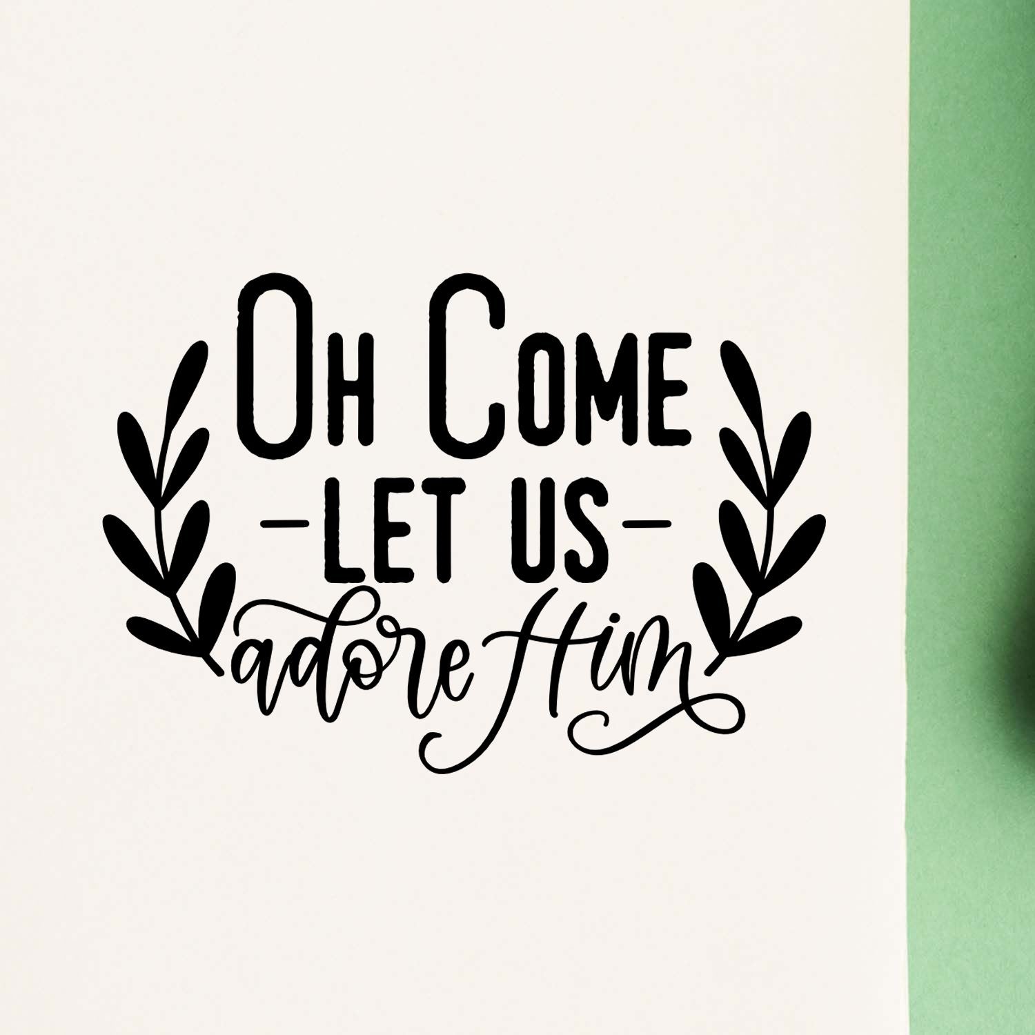 Christmas rubber stamp design reading Oh Come Let Us Adore Him with leafy branches for holiday crafting.