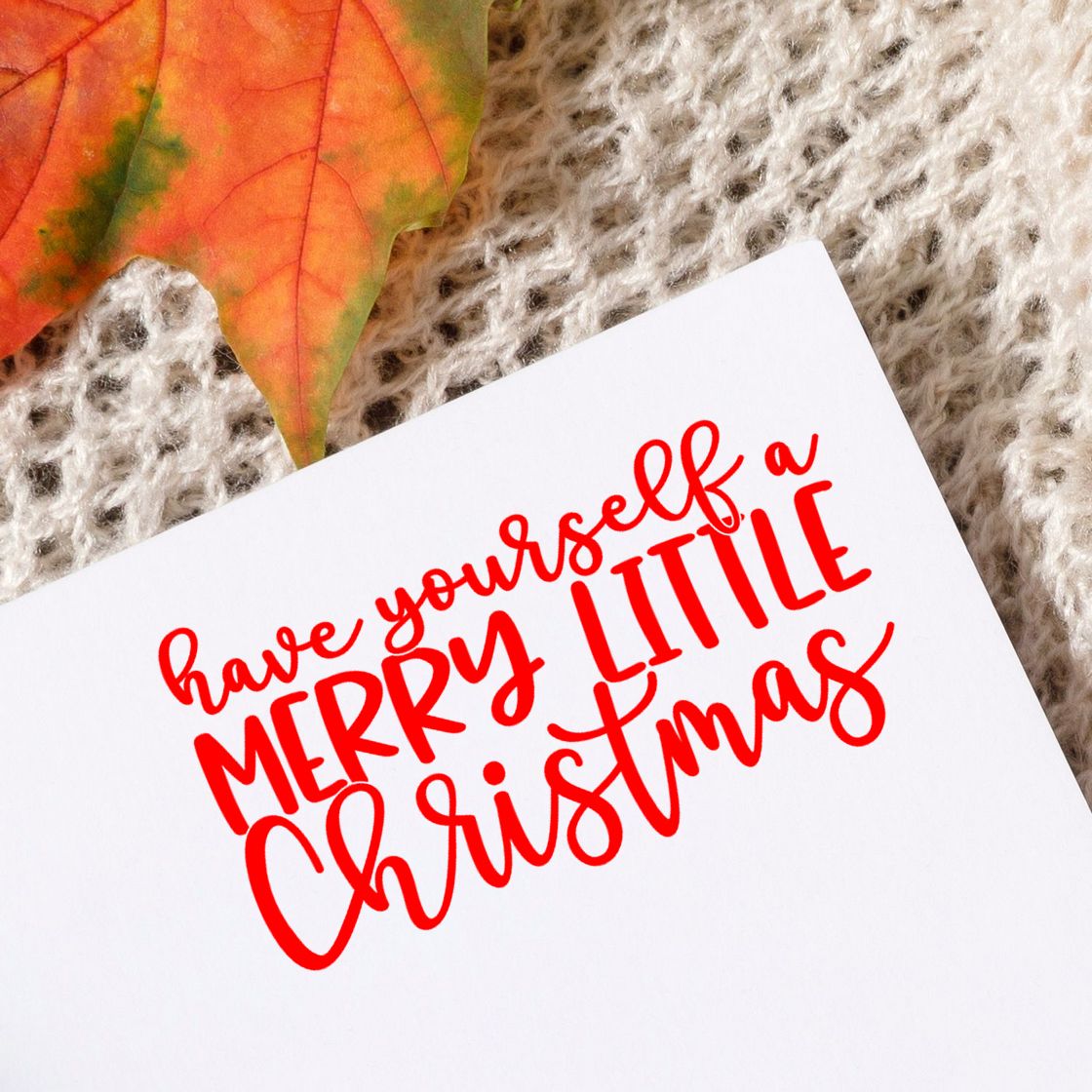 Christmas rubber stamp reading Have Yourself a Merry Little Christmas in red on white card with cozy knit background.