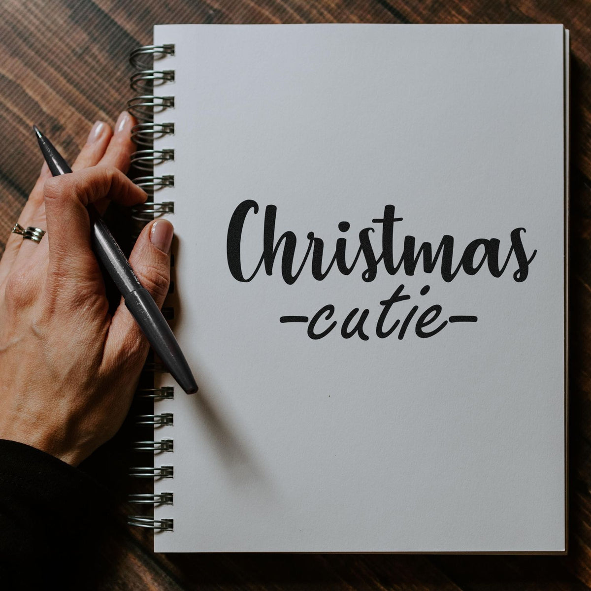Christmas cutie custom rubber stamp design for holiday cards and crafts, shown in a spiral notebook.