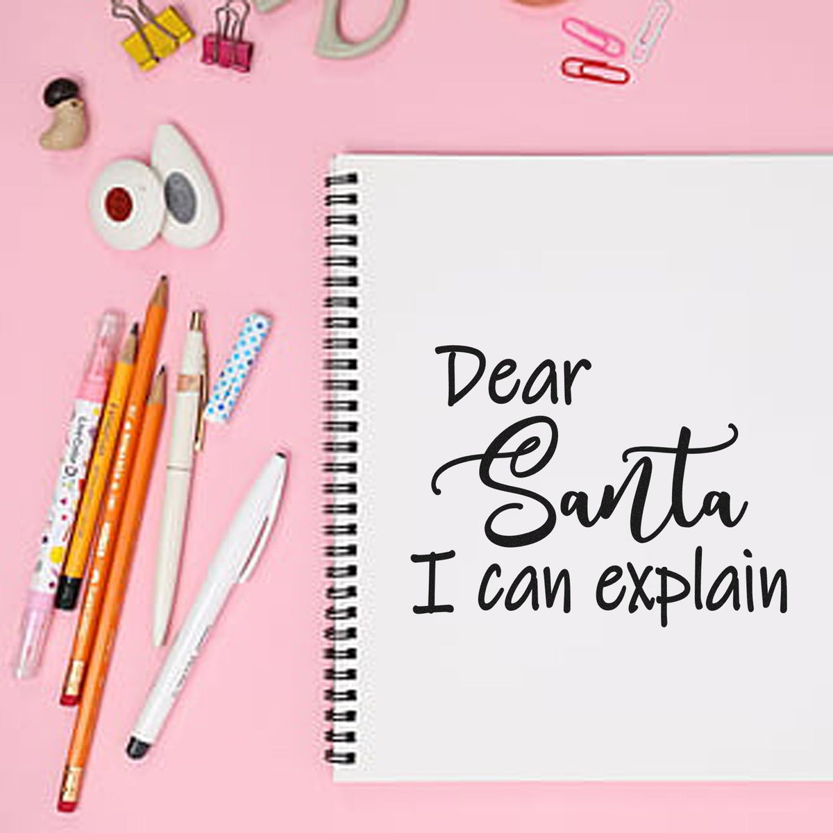 Dear Santa I can explain Christmas rubber stamp design on spiral notebook, with pens on a pink stationery backdrop.