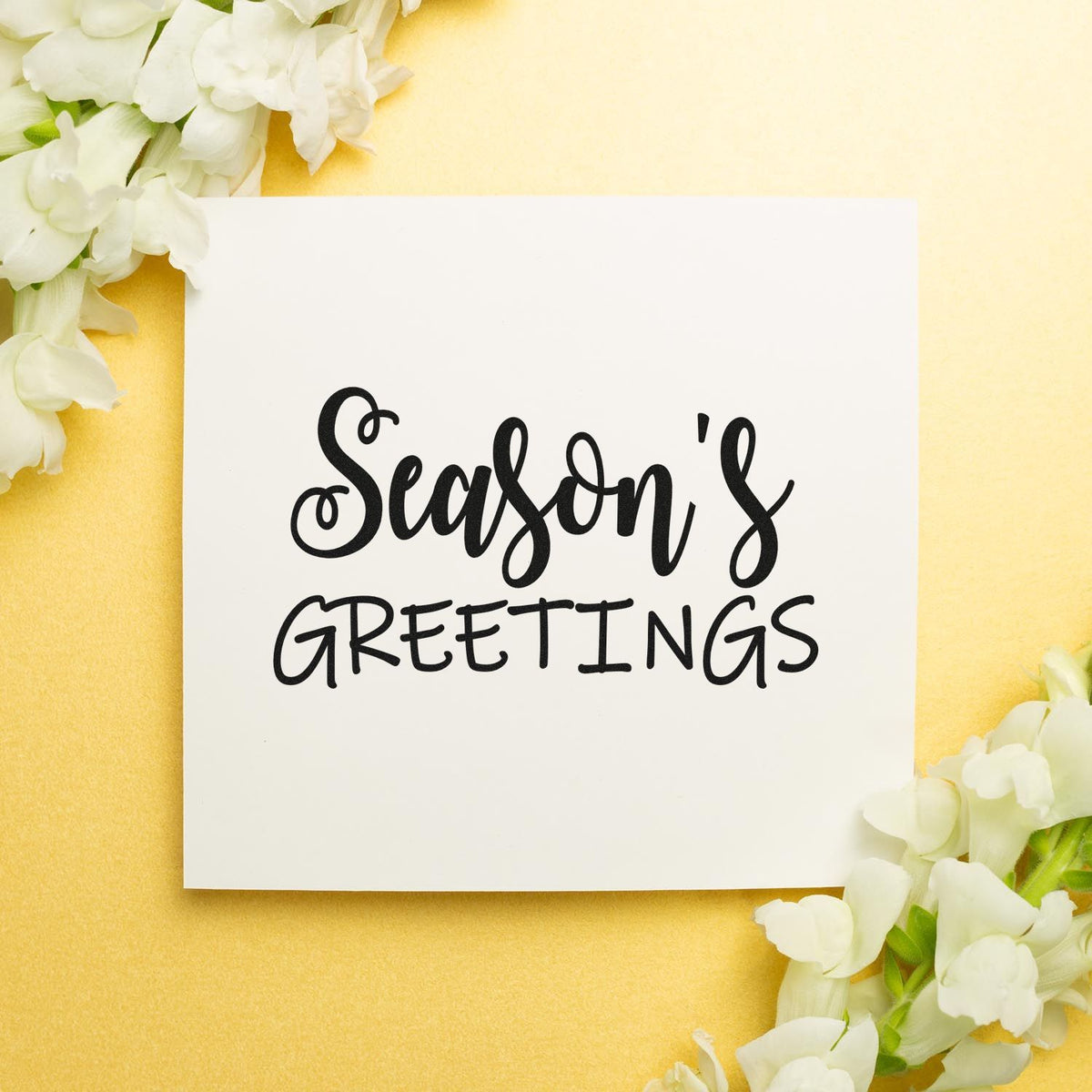 Season's Greetings rubber stamp design for holiday cards, with black lettering on a white card and white flowers.