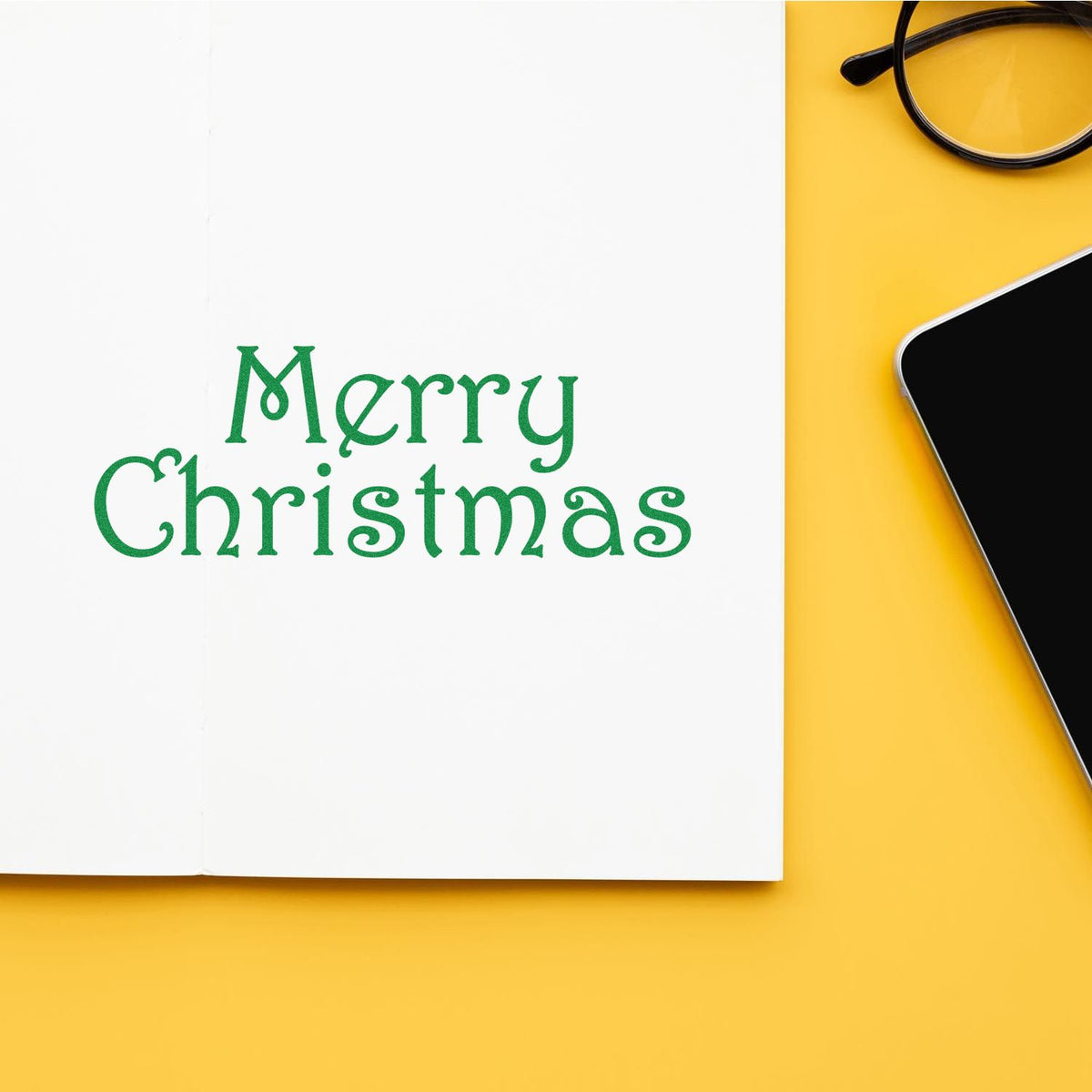 Merry Christmas rubber stamp impression on a notebook page, styled for festive holiday card and craft projects.