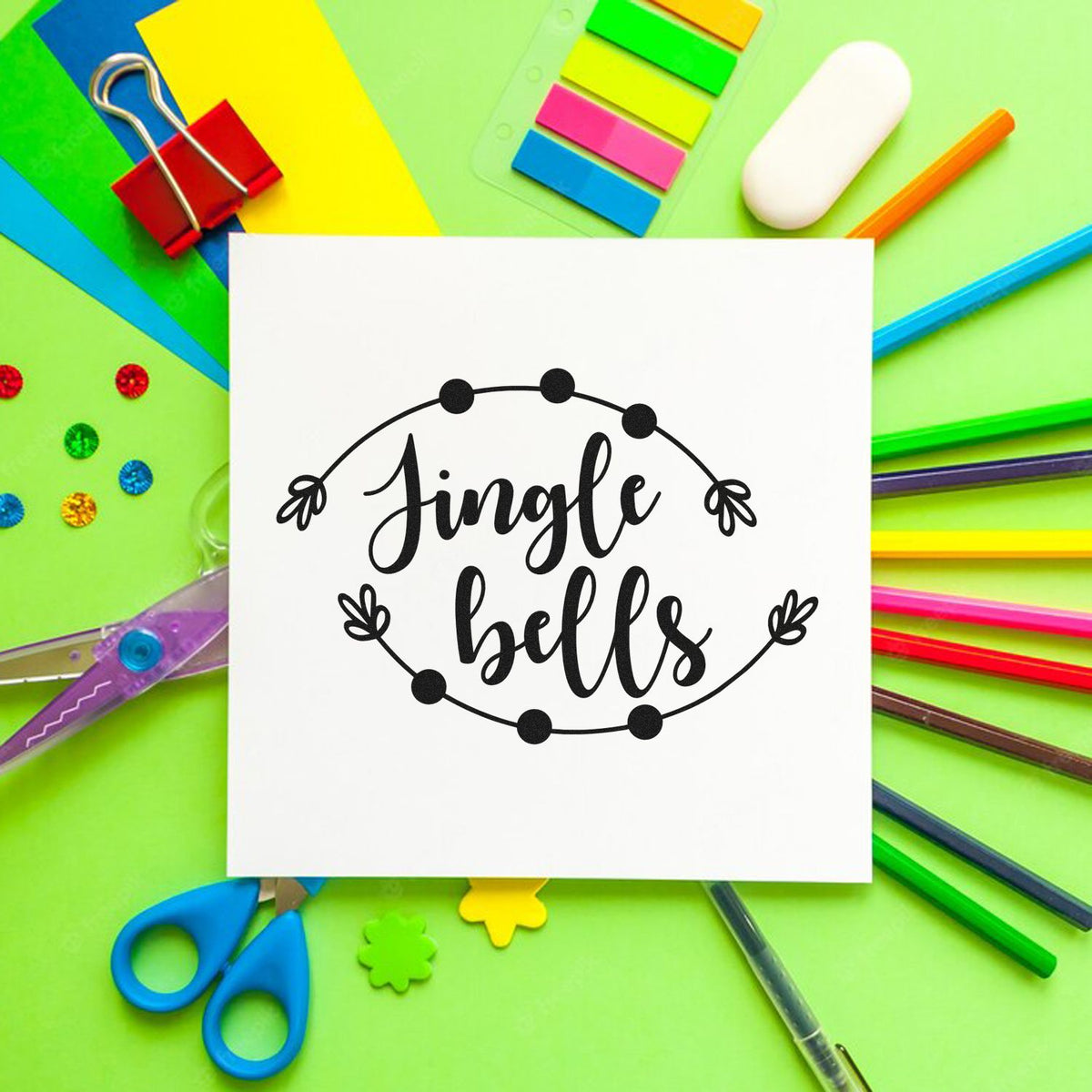 Jingle Bells Christmas rubber stamp design with colorful craft supplies, ideal for holiday card making, scrapbooking, and DIY projects.