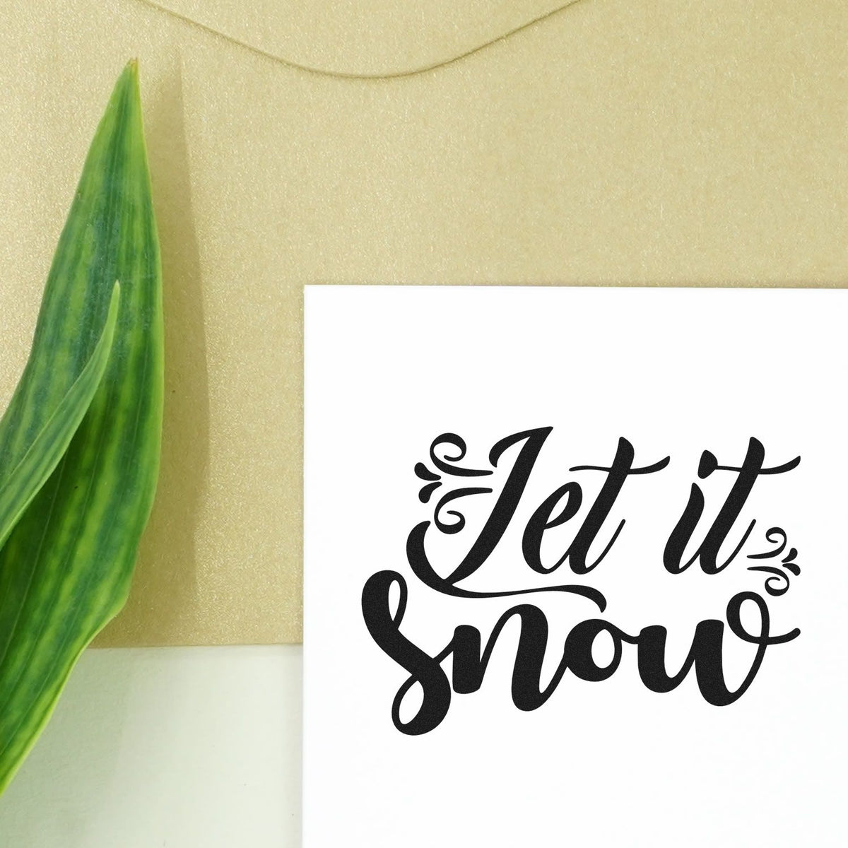 Let It Snow Ornate Script Pre-Inked Stamp – PSI imprint stamped in black ink. “Let It Snow” appears in bold script with curled flourishes at the sides.