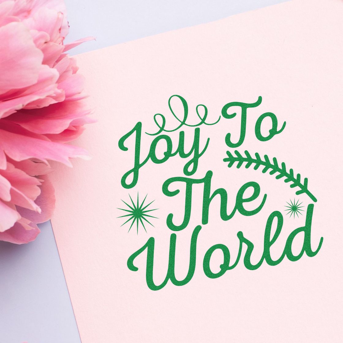 Joy to the World Christmas rubber stamp for holiday cards, featuring green script and floral accents on pink paper.