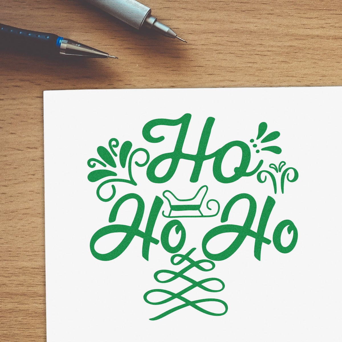 Green Ho Ho Ho Christmas rubber stamp design on paper, ideal for holiday cards and festive craft projects.