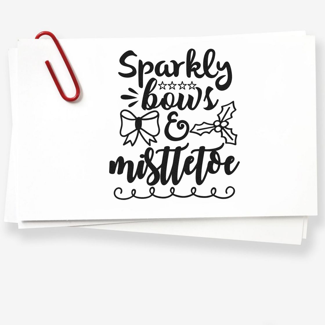 Sparkly bows and mistletoe Christmas rubber stamp design on white paper, ideal for holiday cards, crafts, and festive gift wrapping.