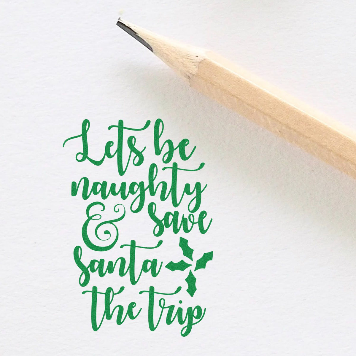 Christmas rubber stamp with Lets be naughty & save Santa the trip holiday phrase and holly accent.