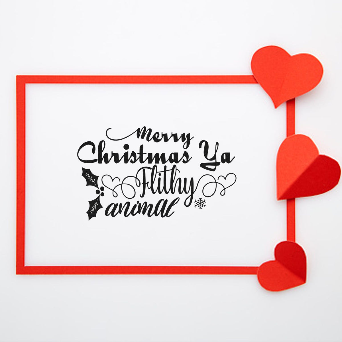 Merry Christmas Ya Filthy Animal rubber stamp design with festive script, holly accents, and hearts for holiday cards.