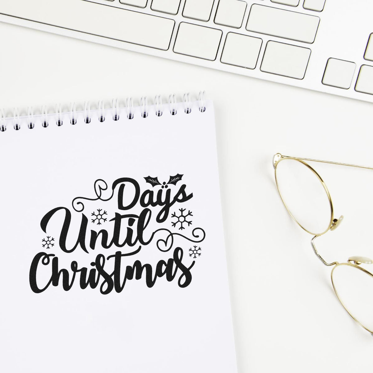 Holiday rubber stamp design reading Days Until Christmas with snowflakes on a notebook.