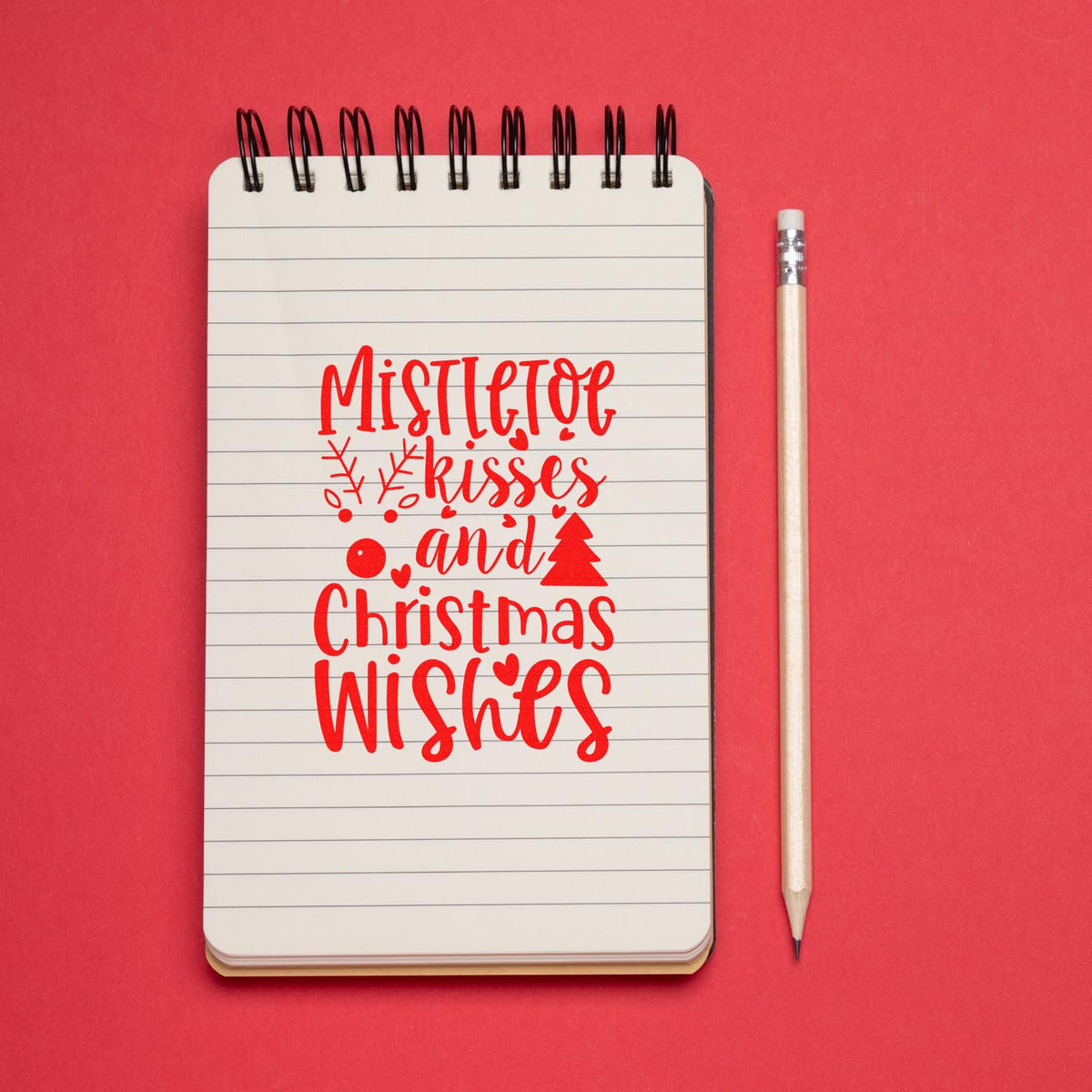 Mistletoe Kisses Christmas Wishes rubber stamp shown in red ink, stamped for projects such as engagement album page.
