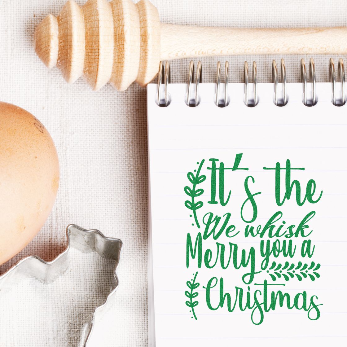 Christmas rubber stamp design with festive baking pun We whisk you a Merry Christmas in green script.