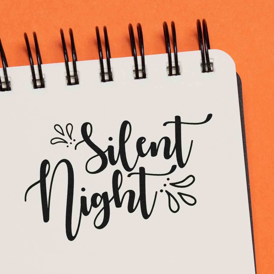 Silent Night rubber stamp for Christmas cards and holiday crafts, shown in elegant script on a notebook page.