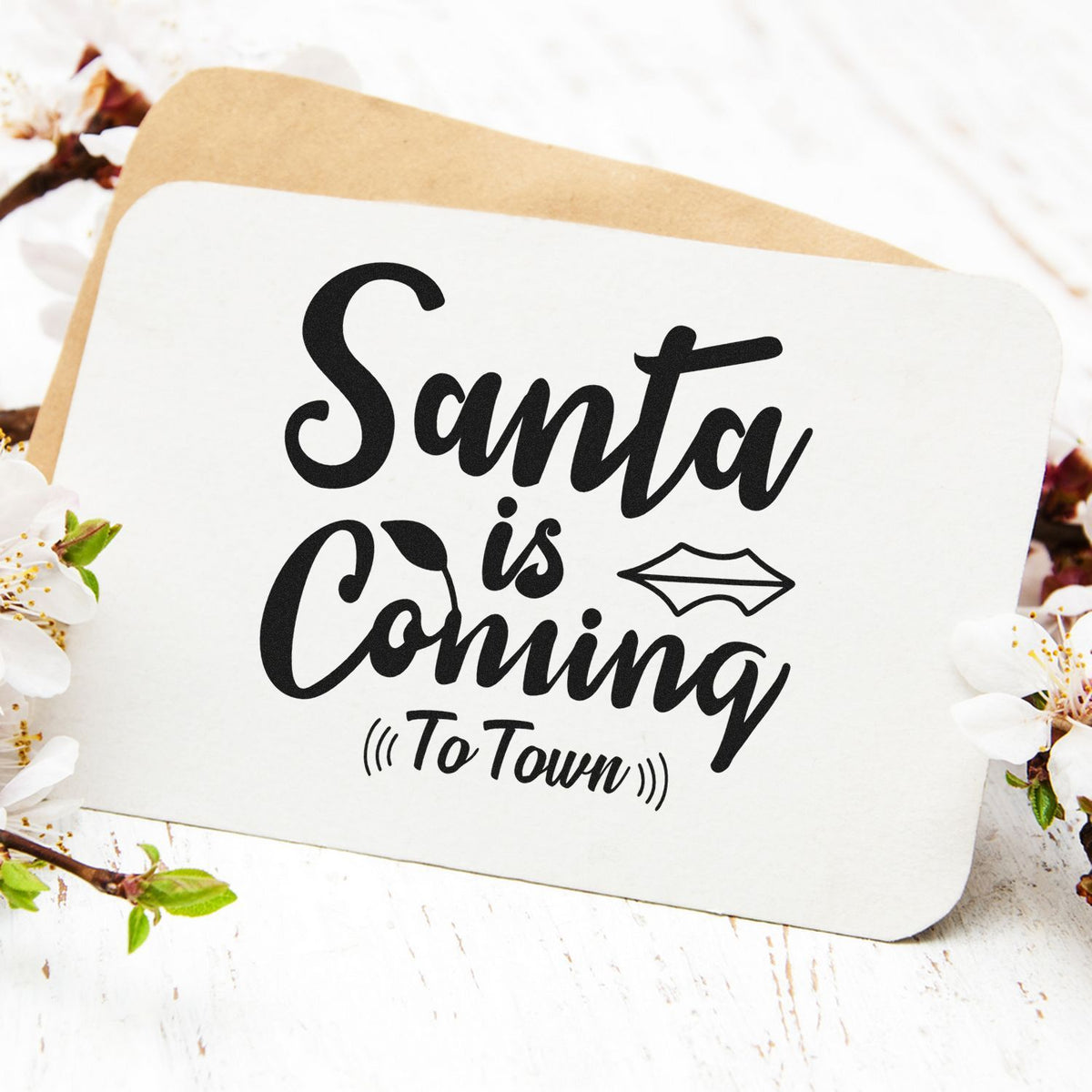 Santa Is Coming To Town Pre-Inked Stamp – PSI imprint stamped in black ink. “Santa Is Coming (To Town)” appears in large brush lettering with a small diamond-shaped accent.