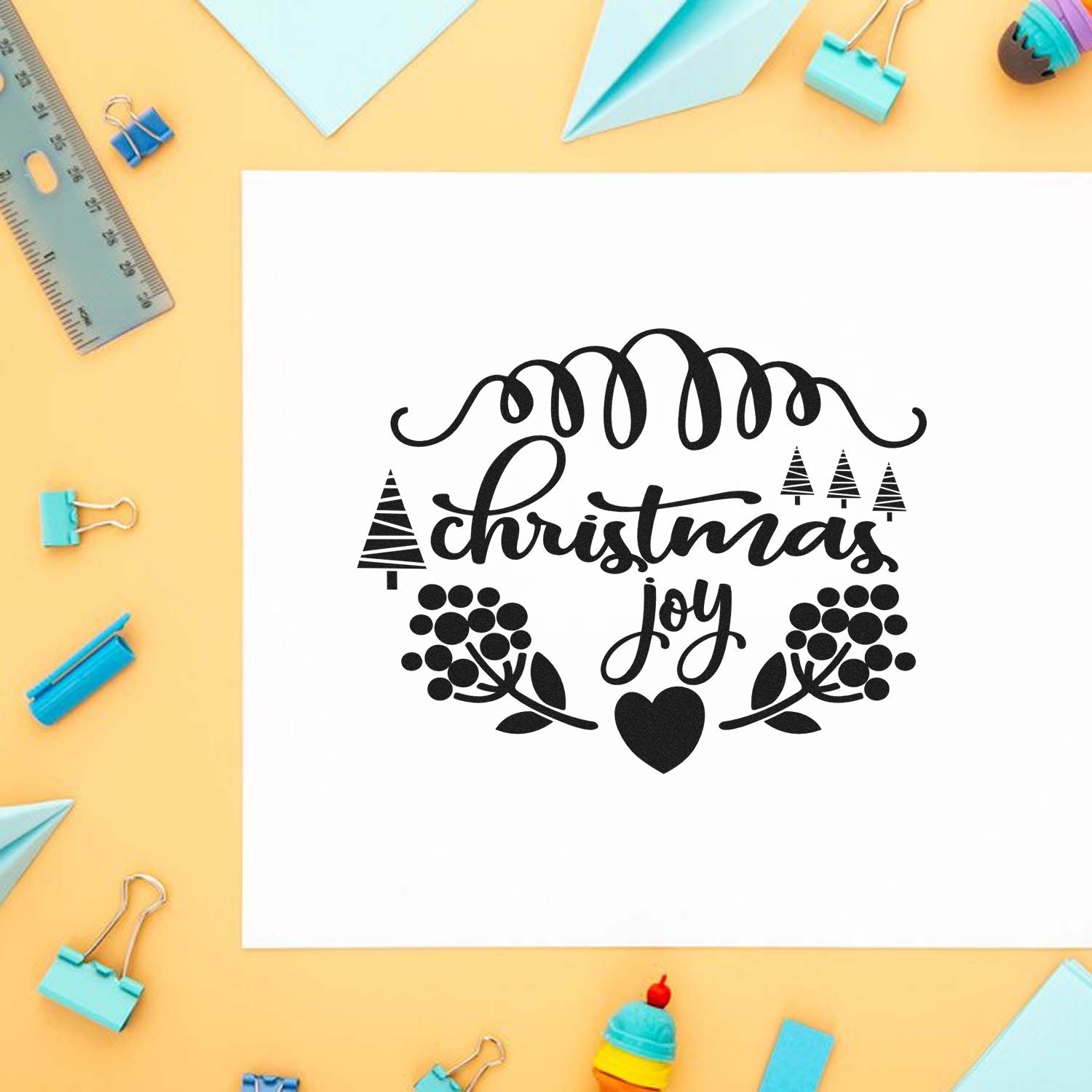 Christmas Joy rubber stamp design for holiday crafting, shown on white paper with festive stationery flat lay.