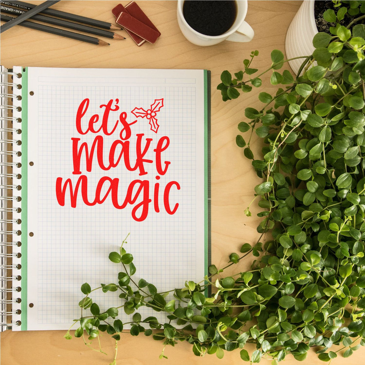 Red rubber stamp phrase lets make magic on a notebook, ideal for holiday card making, planners, and craft projects.
