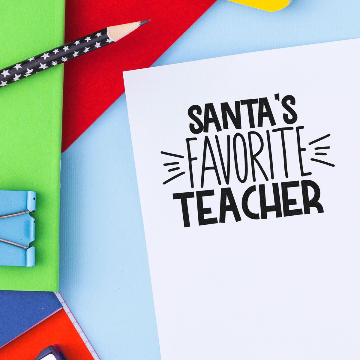 Santas Favorite Teacher rubber stamp design for holiday teacher gifts on white paper with colorful school supplies.