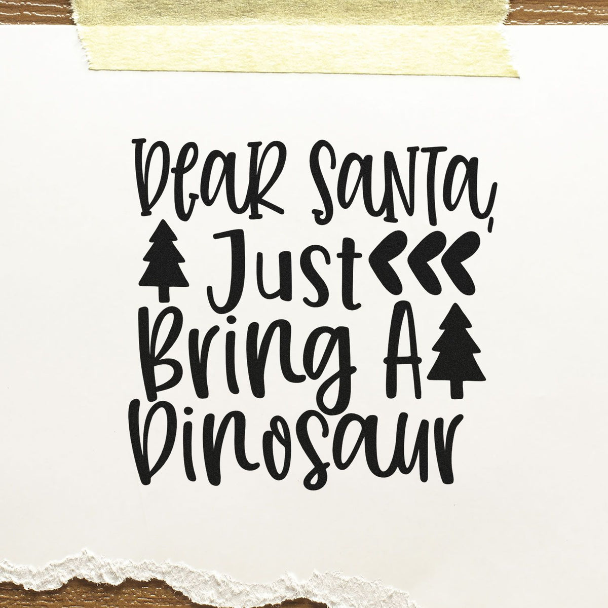 Dear Santa Just Bring A Dinosaur Premium Wooden Stamp - Vintage Pro imprint stamped in black ink. "Dear Santa Just Bring a Dinosaur" features pine silhouettes and triple chevrons.