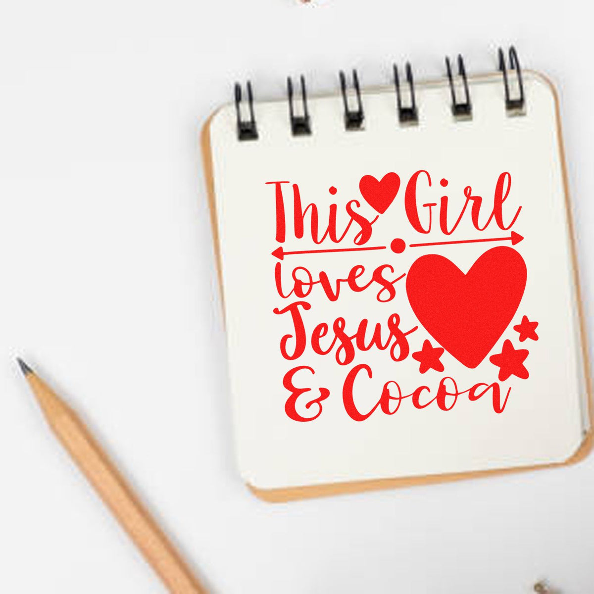 Rubber stamp design reading This Girl Loves Jesus & Cocoa with heart and stars on a notebook page.