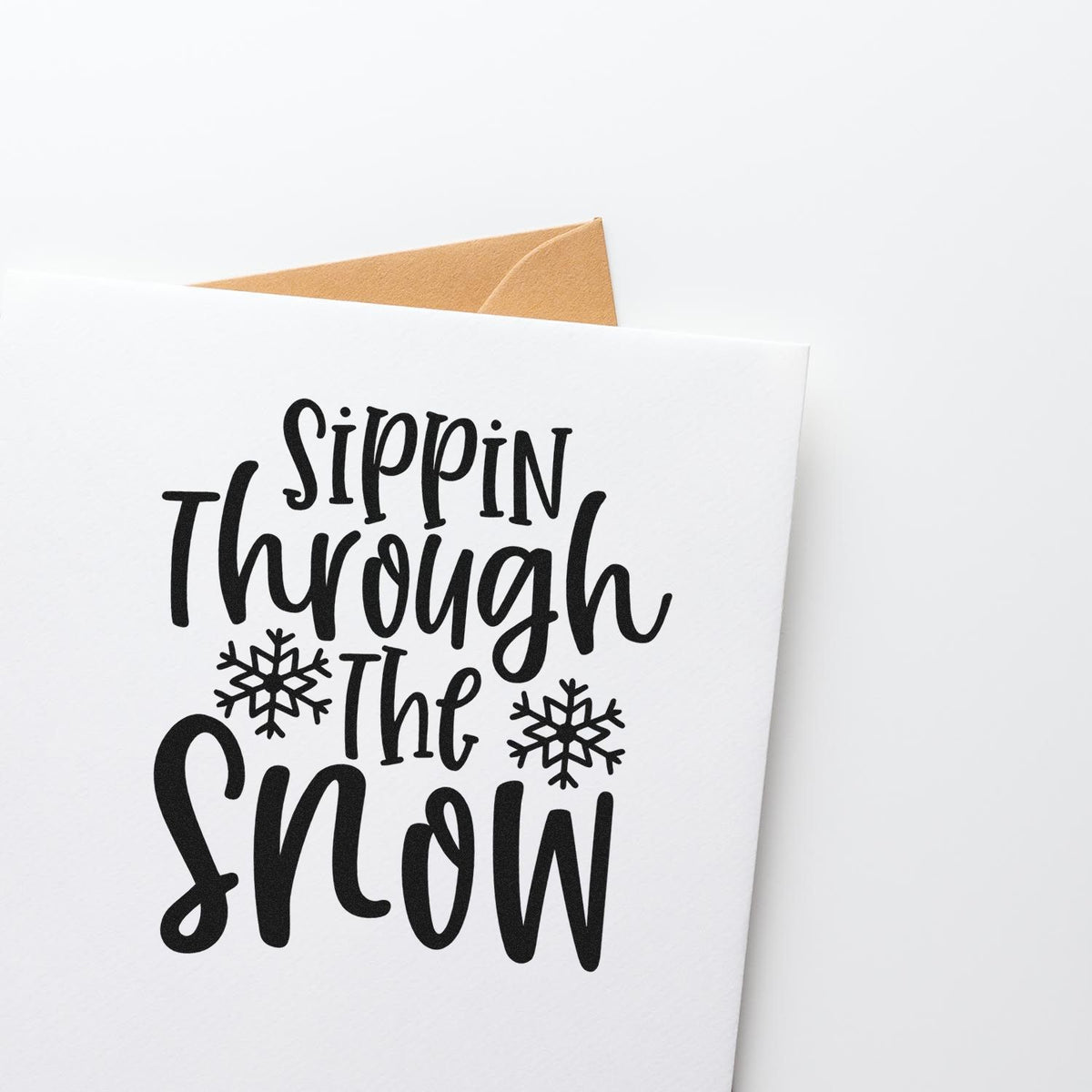 Sippin Through The Snow Stamp – PSI Pre-Inked imprint stamped in black ink. “Sippin Through the Snow” appears in tall playful lettering with two snowflakes.