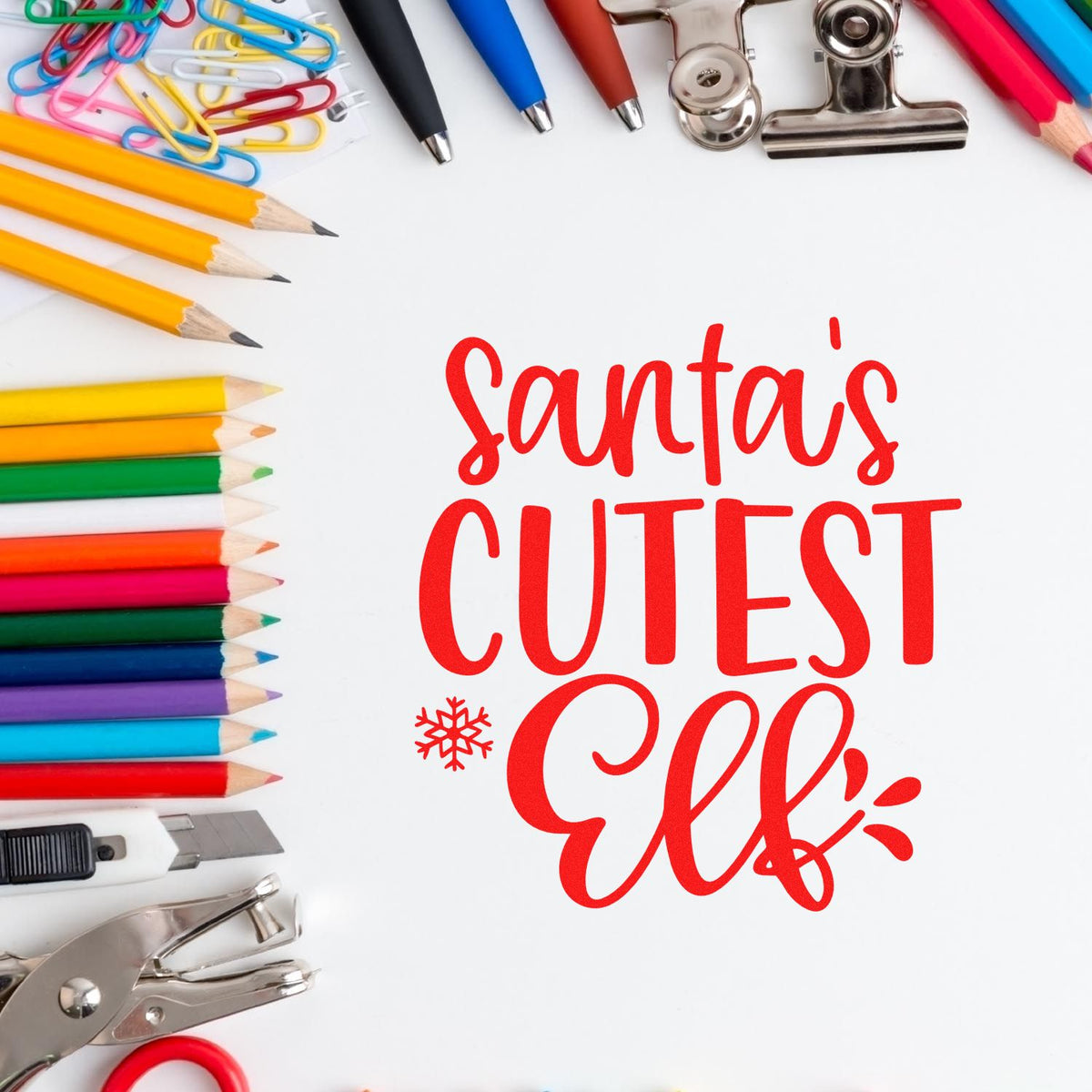Christmas rubber stamp design reading Santas Cutest Elf, surrounded by colorful school and office supplies.