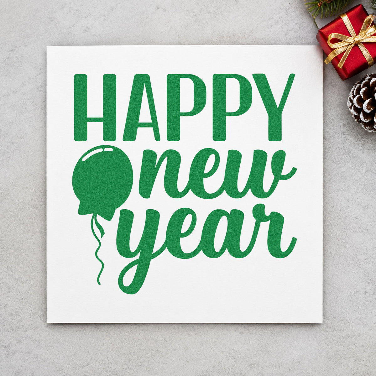 Happy New Year Balloon craft stamp imprint in green ink on a handmade project, one idea being noisemaker favor tags.