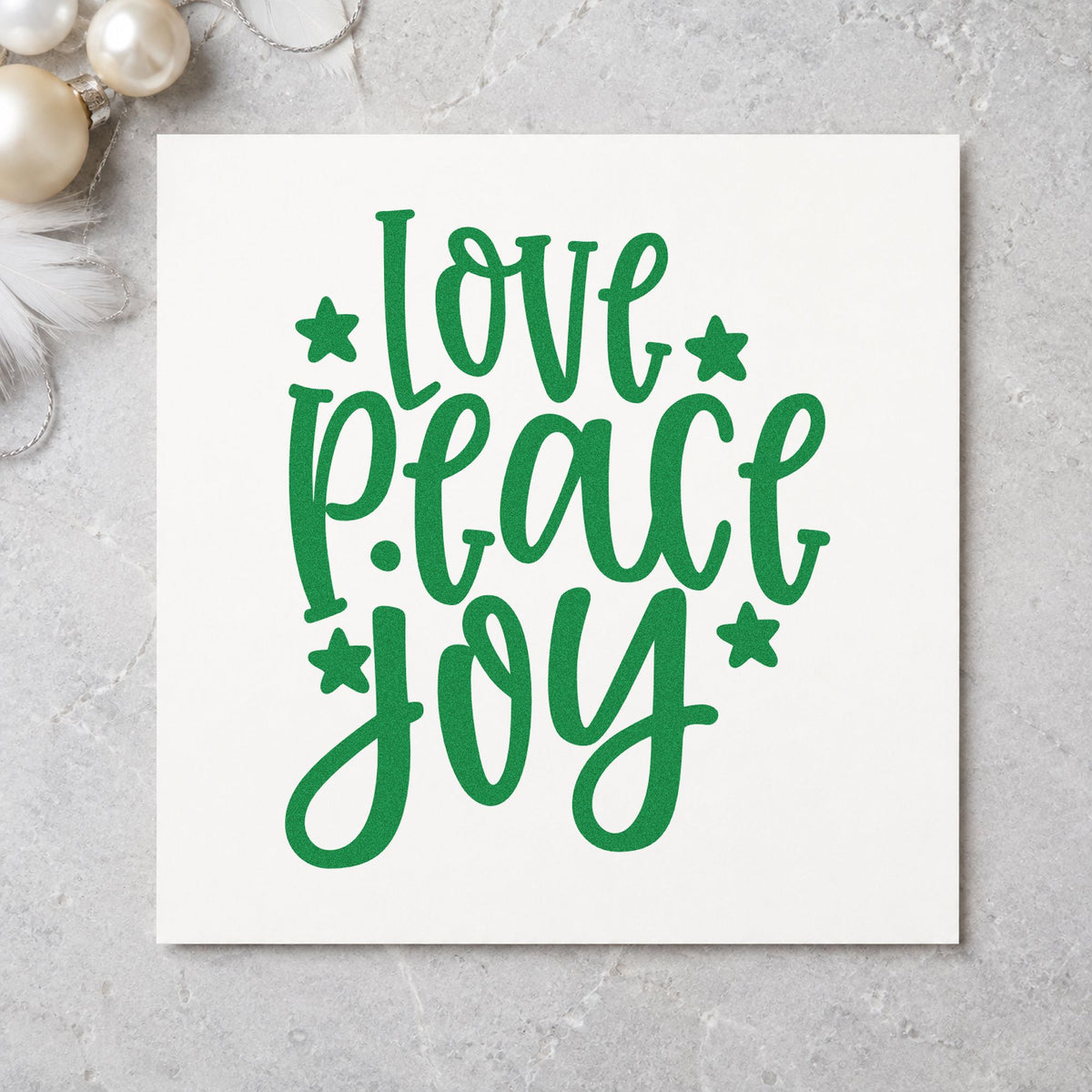 Love Peace Joy Stars craft stamp imprint in green ink on a handmade project, one idea being advent week cards.