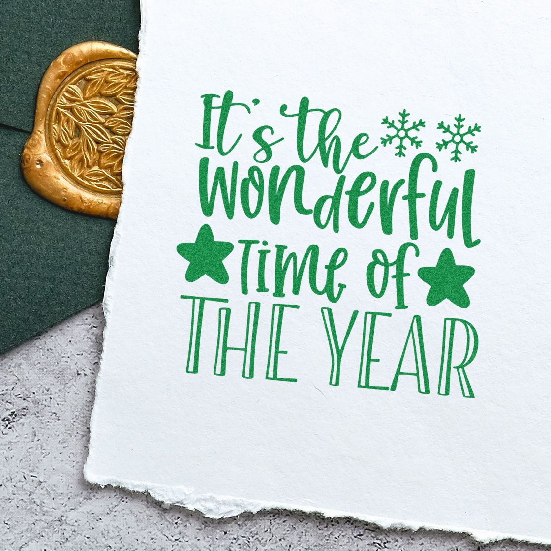 Christmas rubber stamp reading Its the Wonderful Time of the Year in green, with stars and snowflakes on handmade paper.