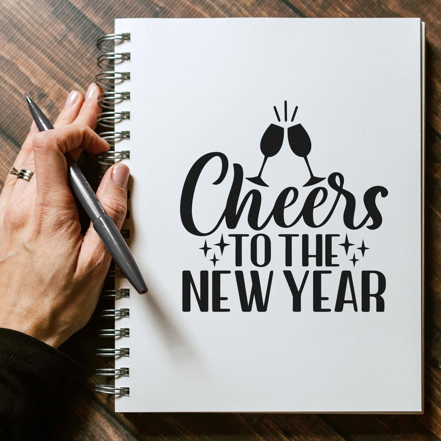 Cheers to the New Year rubber stamp design mockup with clinking champagne glasses for holiday cards and craft projects.