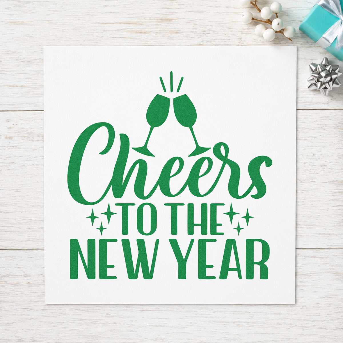 Cheers To The New Year craft stamp imprint in green ink on a handmade project, one idea being flute charm tags.