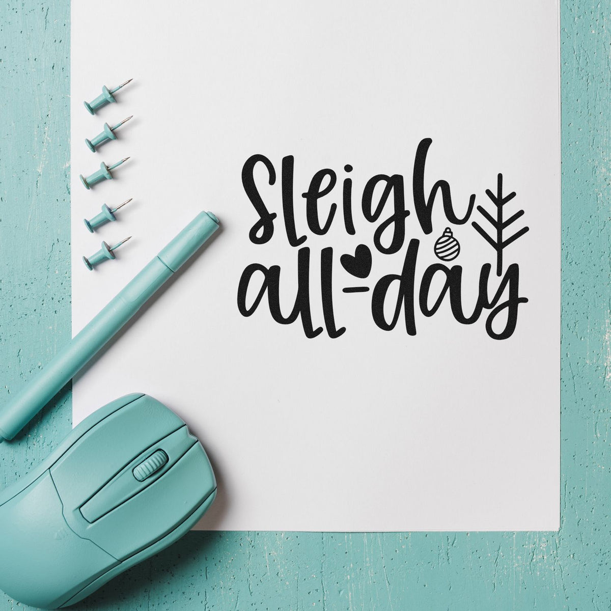 Sleigh all day Christmas rubber stamp design on paper with teal stamping tools and holiday craft supplies.