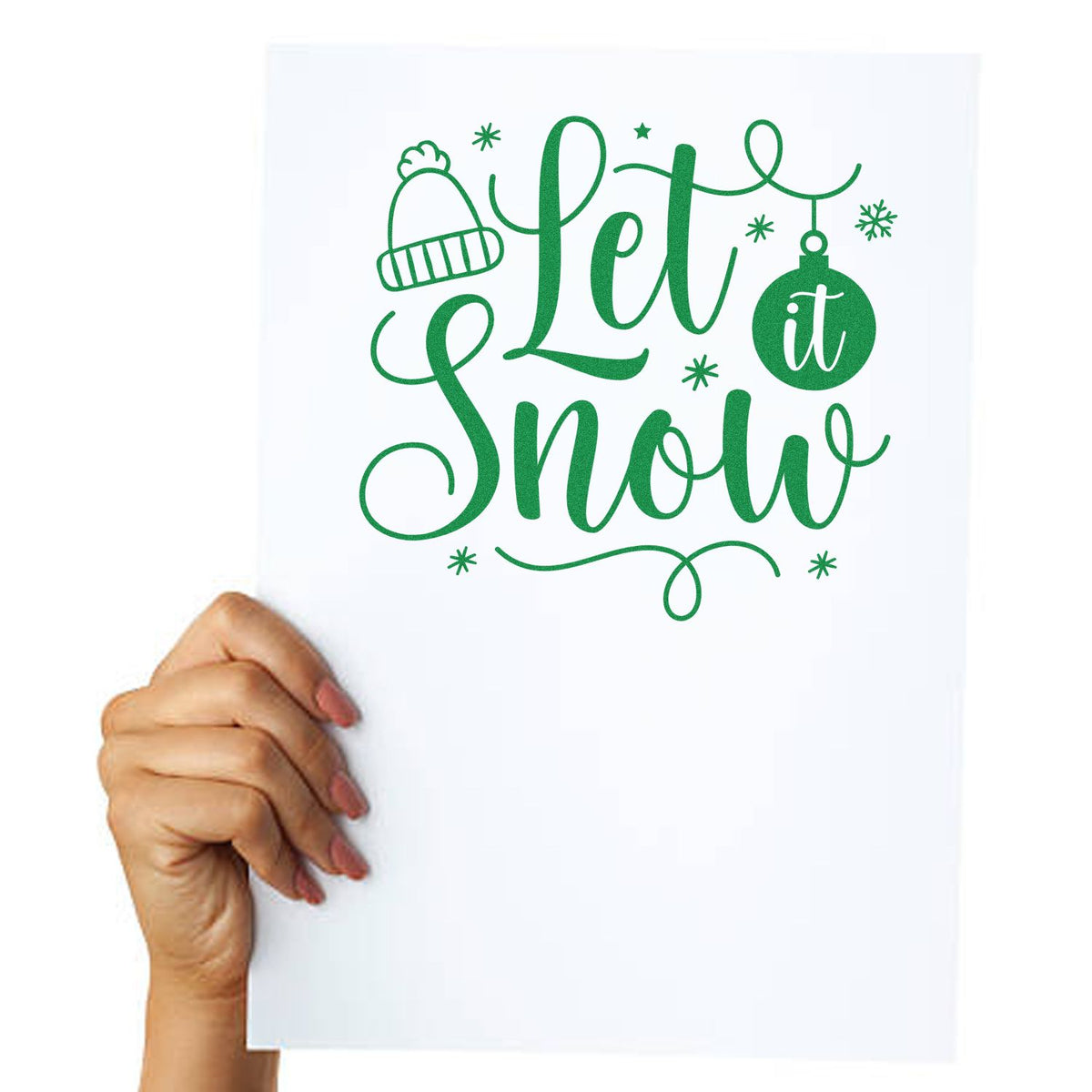 Custom rubber stamp mockup with Let it Snow winter design, hat ornament, and snowflakes on white paper