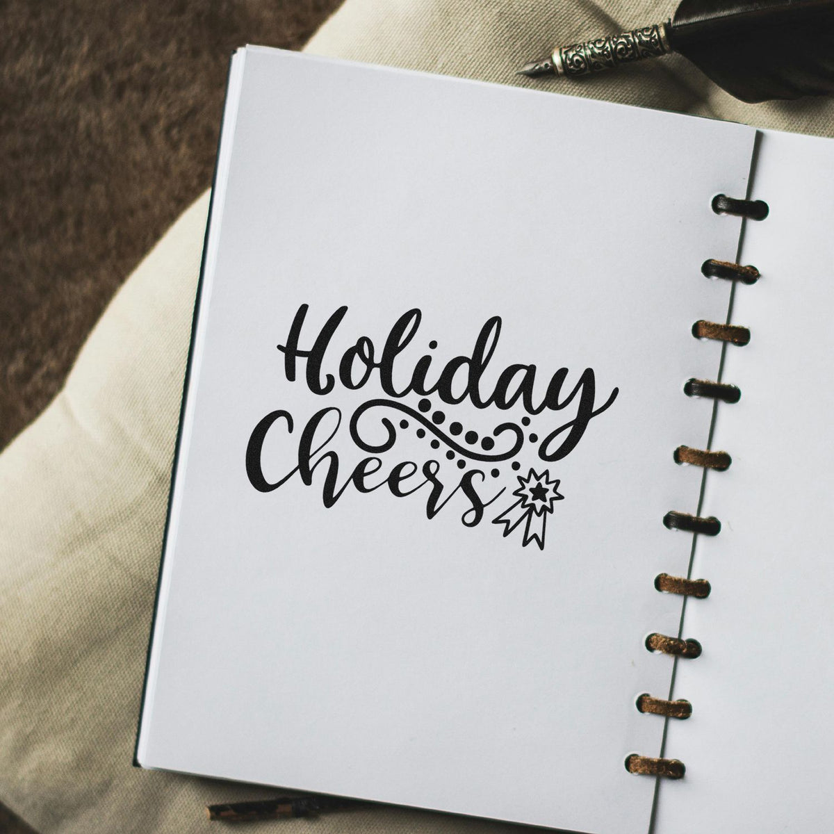 Holiday Cheers rubber stamp design on notebook page with decorative script and festive accent, ideal for holiday card crafting.