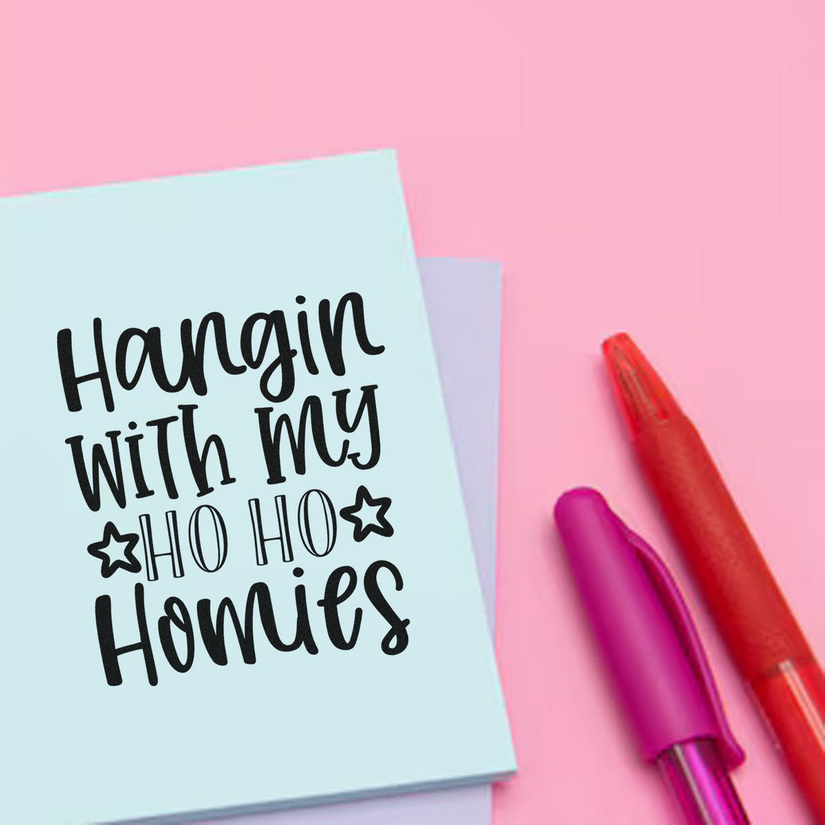 Christmas rubber stamp design with Hangin with my Ho Ho Homies lettering on pastel card, shown with colorful pens.