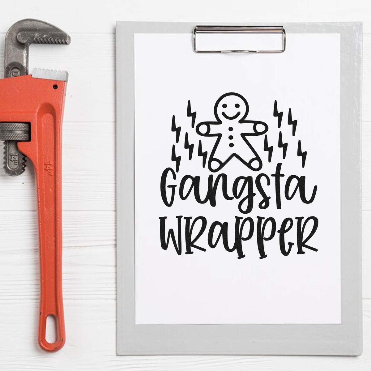 Gangsta Wrapper rubber stamp design with gingerbread man and lightning bolts beside a pipe wrench on a clipboard.