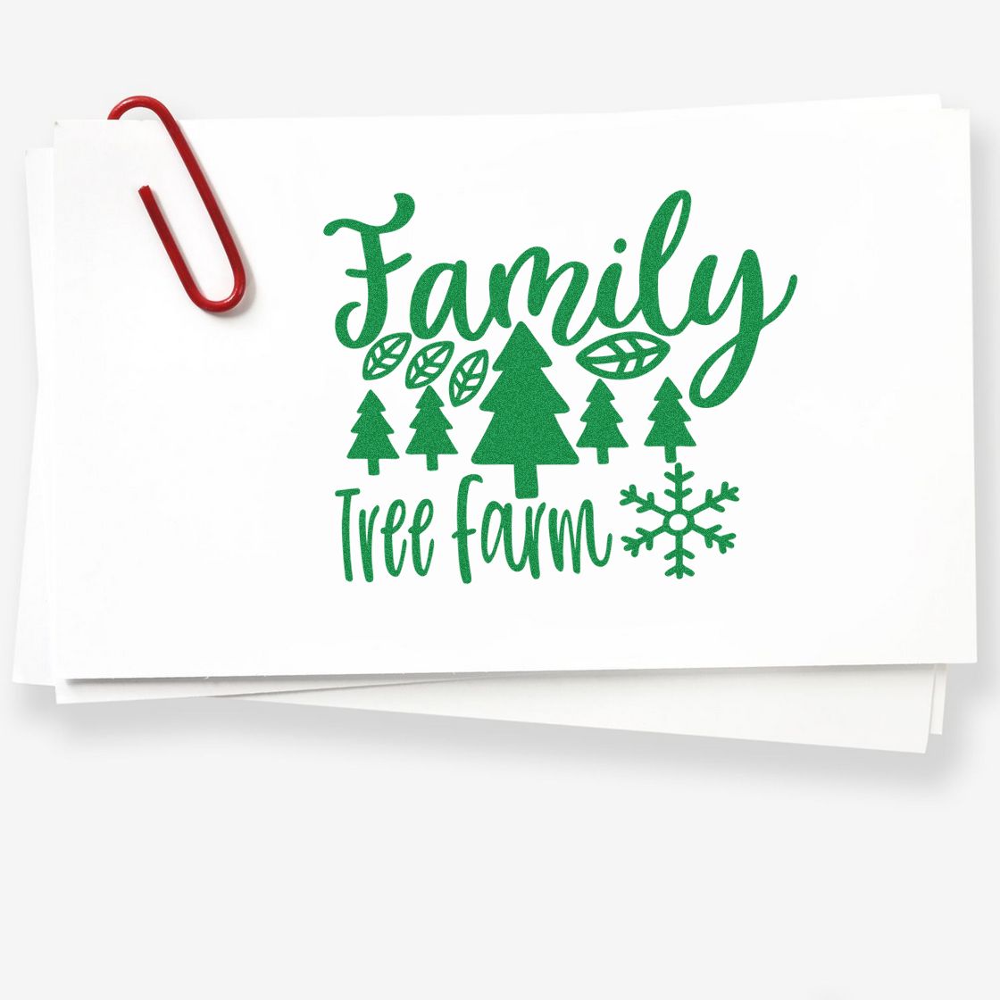Family Tree Farm rubber stamp design with green pine trees and snowflake on white paper, ideal for holiday cards and rustic crafts.