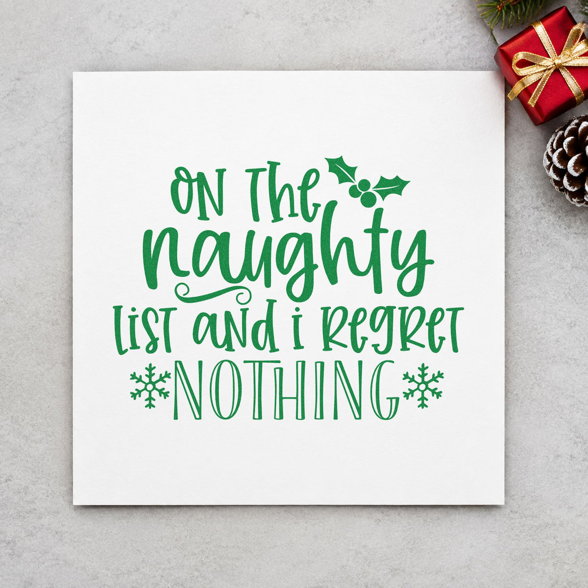 Naughty List Regret Nothing craft stamp imprinted in green ink on paper, a design suited to framed entry hook.