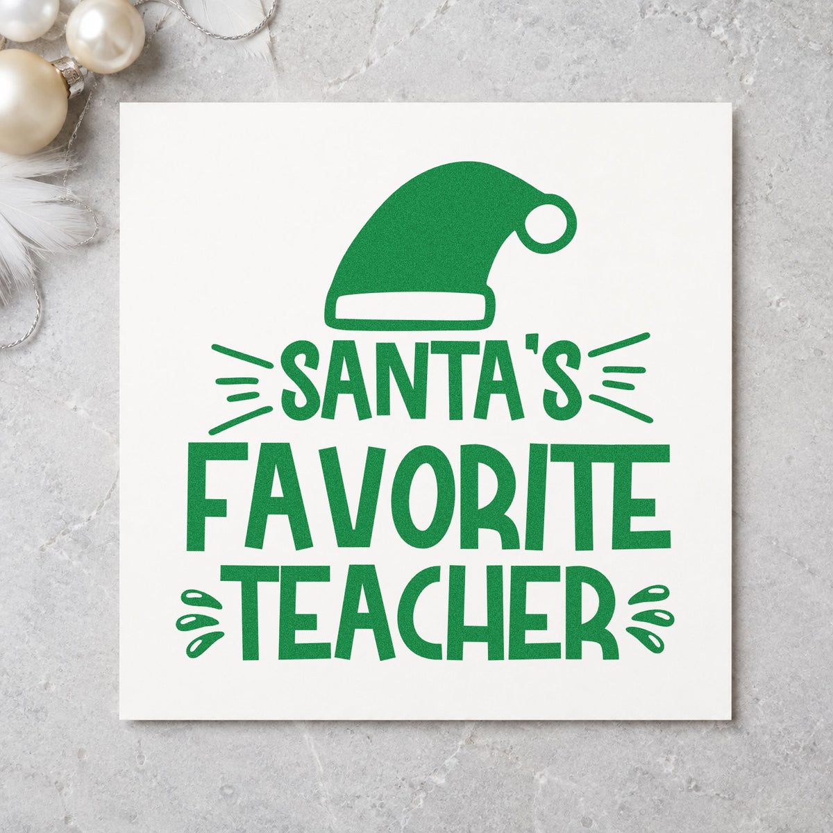 Santa's Favorite Teacher Hat craft stamp imprint in green ink on a handmade project, one idea being room parent tags.