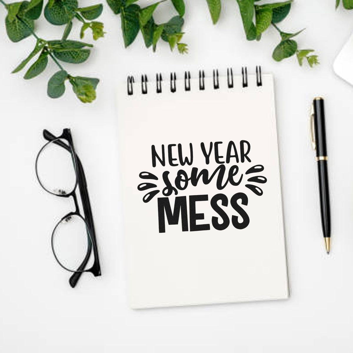 New Year Some Mess rubber stamp design on notebook for planner journaling, with pen, glasses and greenery.