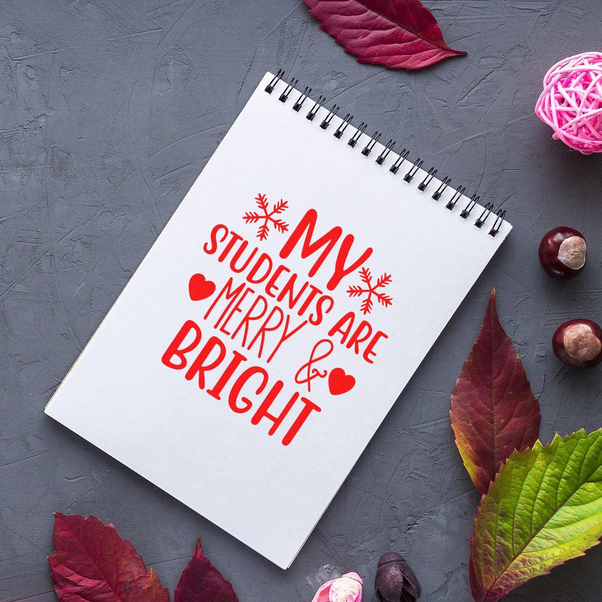 Holiday rubber stamp design on notebook reading My Students Are Merry & Bright for teacher Christmas cards and classroom crafting.