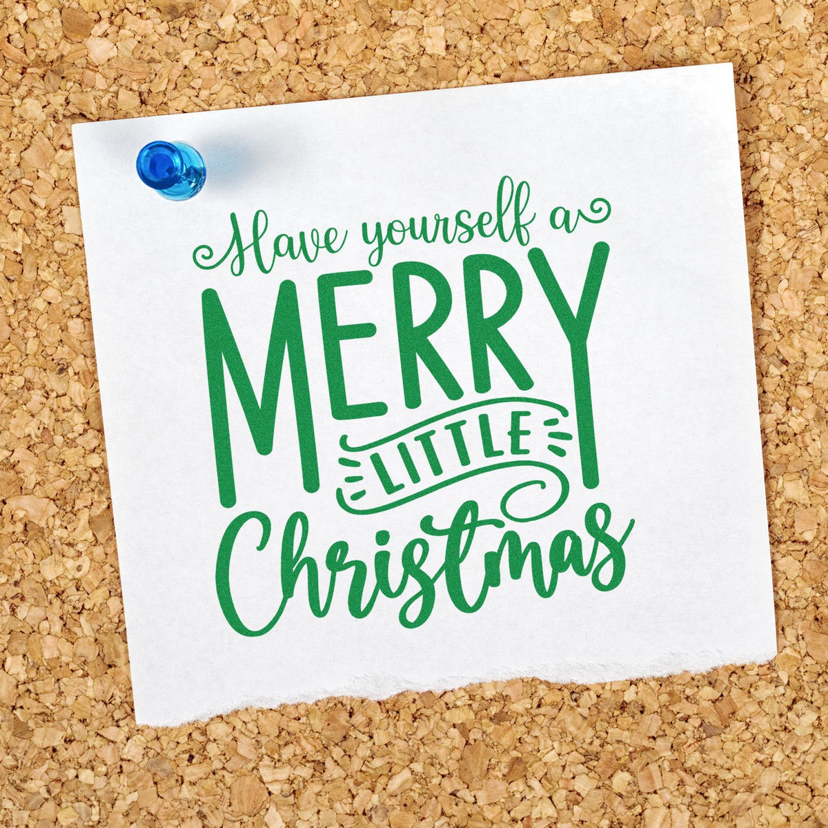 Green Have Yourself a Merry Little Christmas rubber stamp design on paper pinned to a corkboard.