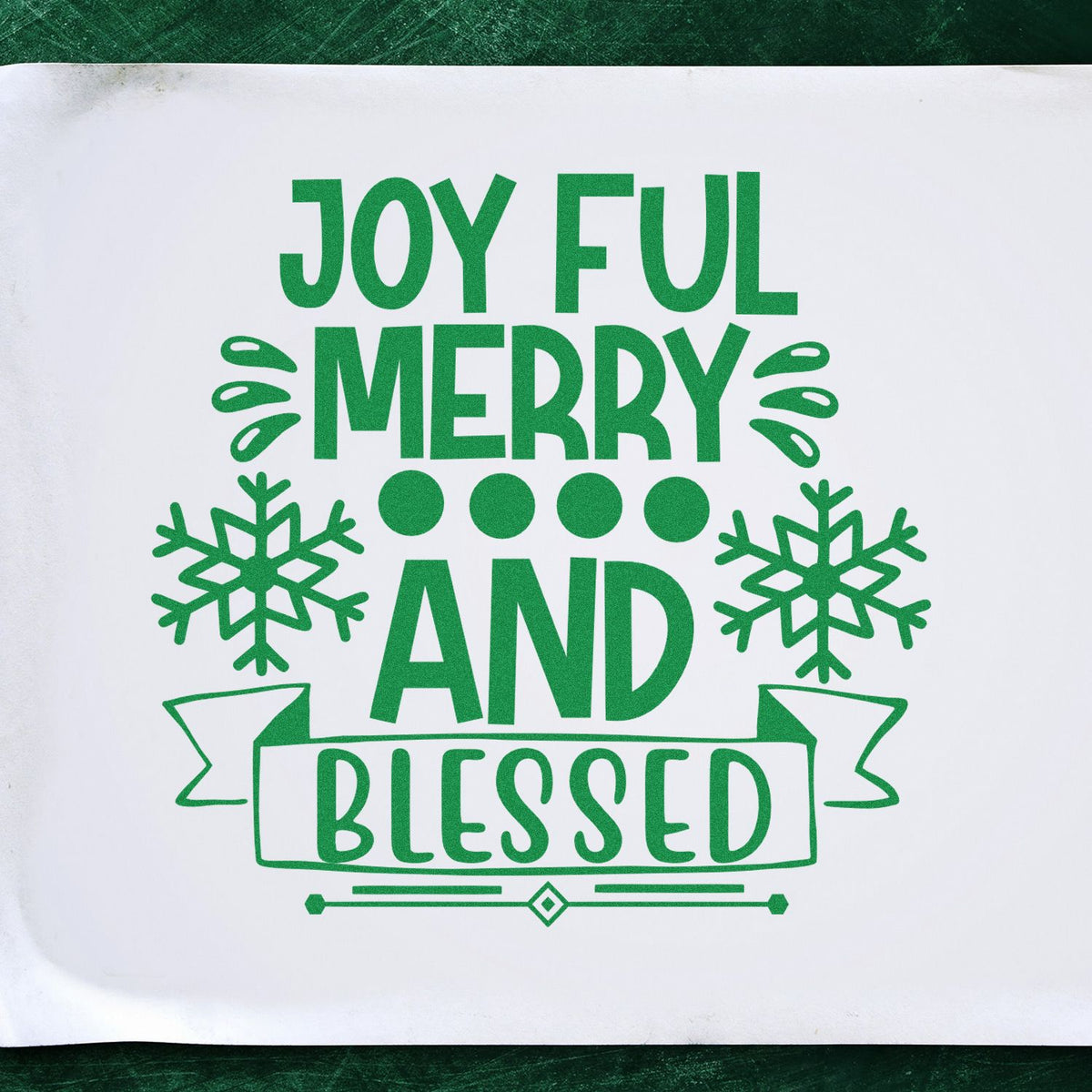 Joyful Merry Blessed Snowflake Banner rubber stamp shown in green ink, stamped for projects such as emphasis album page.