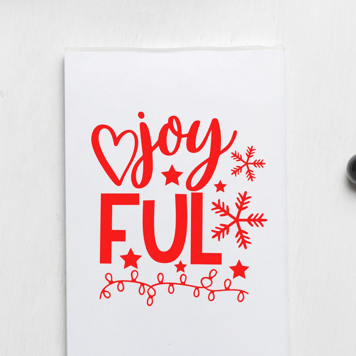 Christmas rubber stamp design with red joyful lettering, snowflakes, stars and string lights for holiday card making.