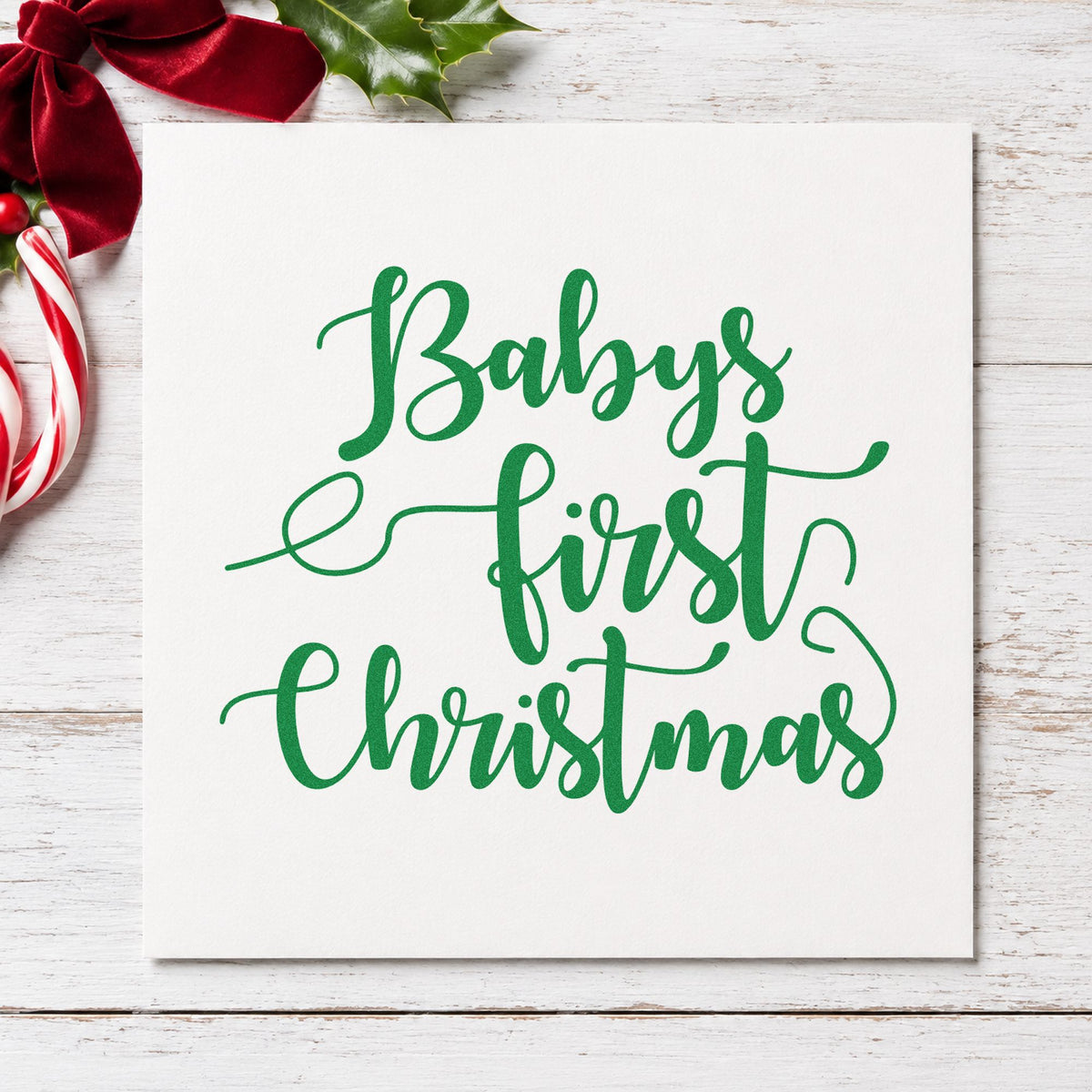 Baby's First Christmas Script craft stamp imprinted in green ink on paper, a design suited to framed crib wall.