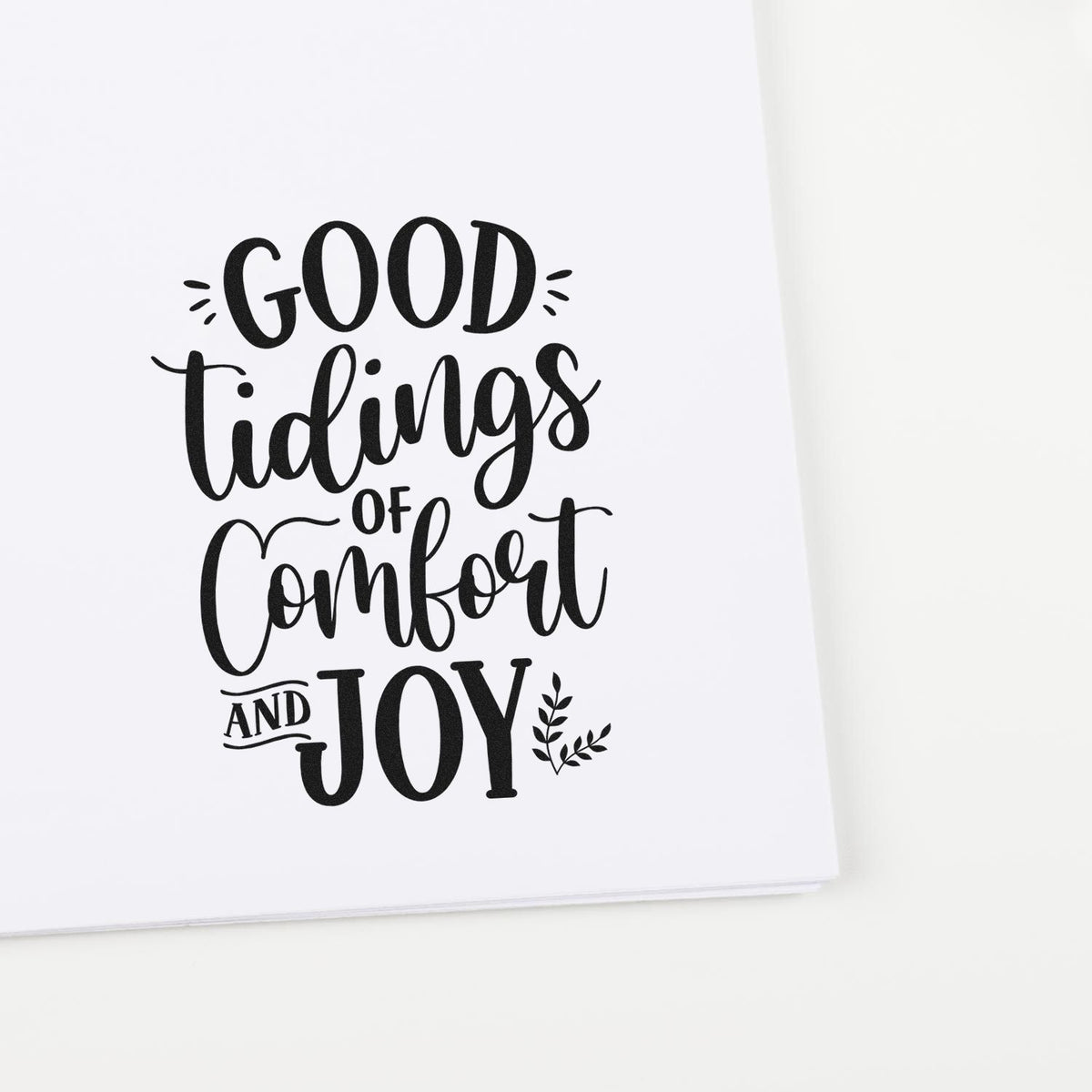 Good tidings of comfort and joy holiday rubber stamp design with decorative black lettering on white paper.