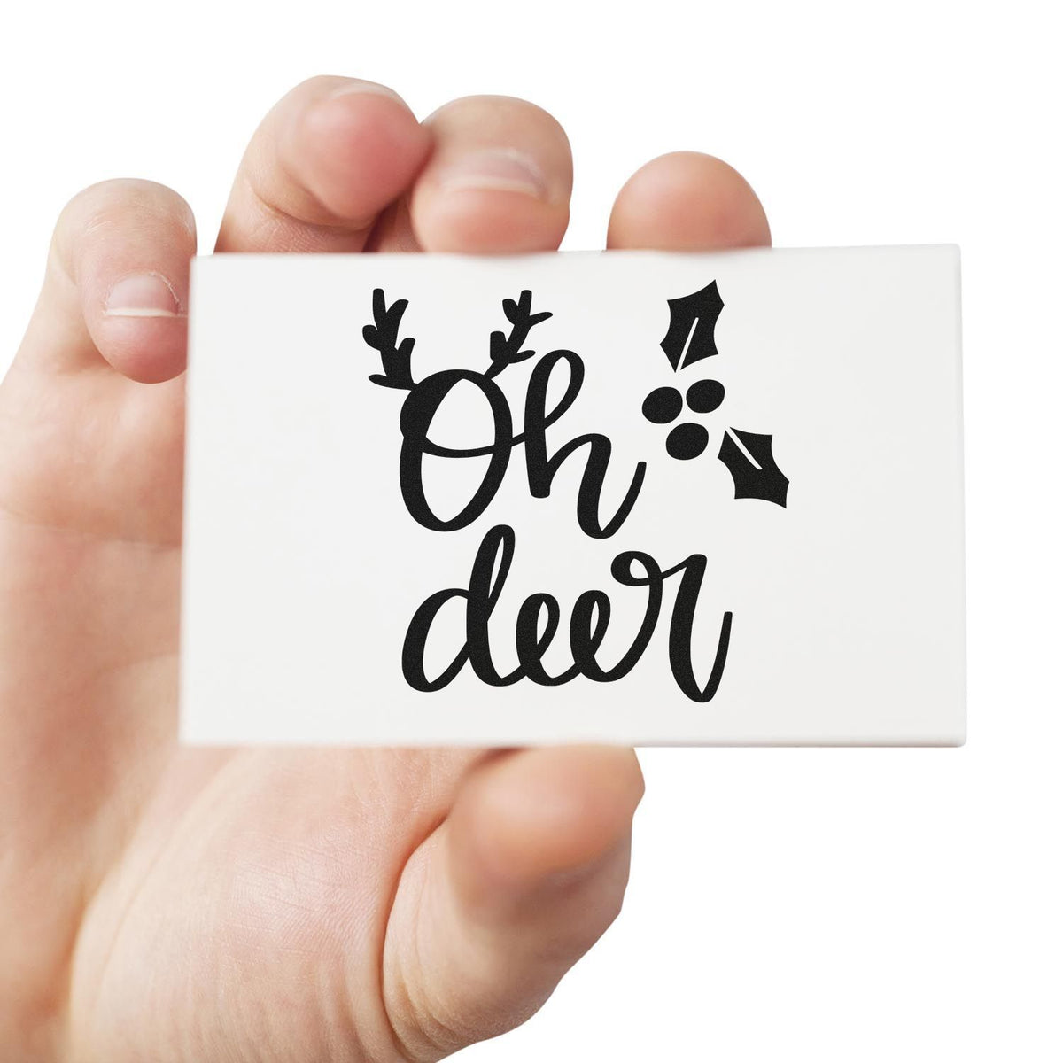 Oh deer holiday rubber stamp with holly and antler design, held in hand for festive card making and Christmas crafts.